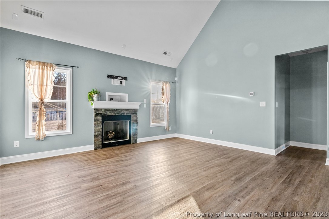 108 Roy's Ridge Raeford, NC 28376 - Photo 6 of 32 an empty room with wooden floor fireplace and windows