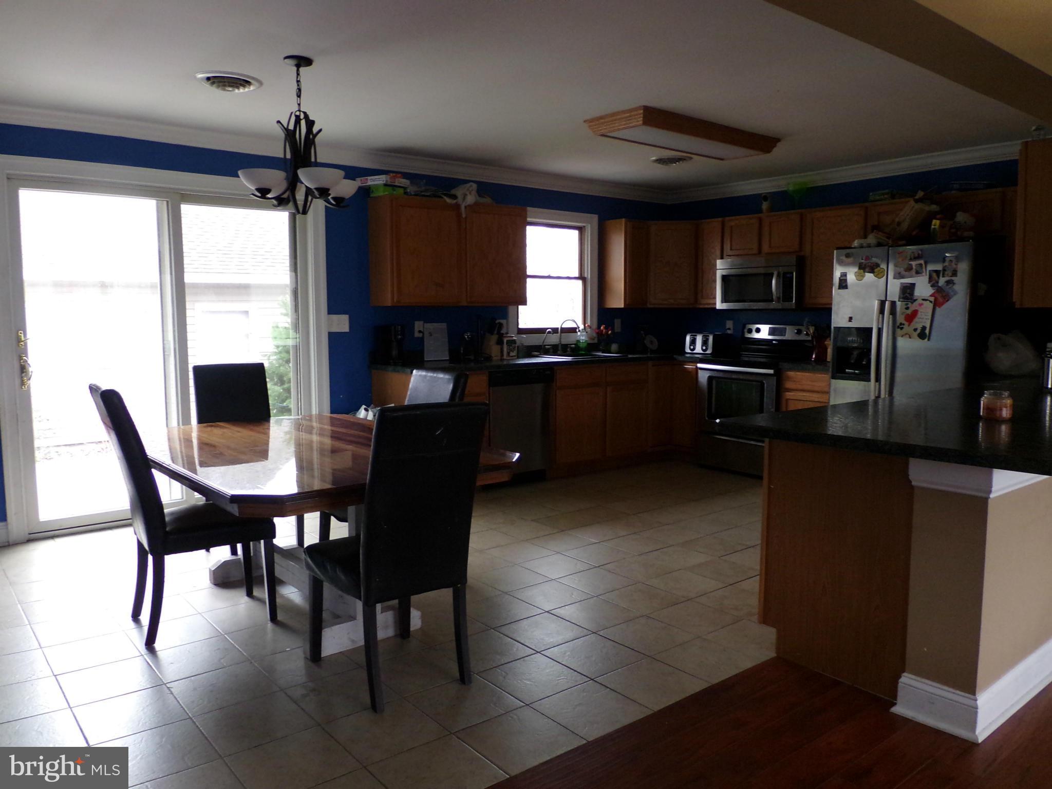 29012 Rabbit Hill Road Easton, MD 21601 - Photo 12 of 22 a kitchen with a dining table chairs and refrigerator