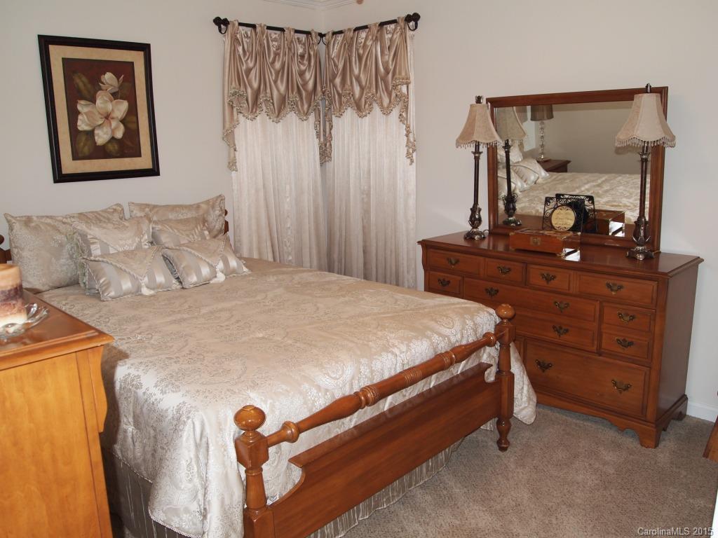 603 Panthers Way, Unit 190 Fort Mill, SC 29708 - Photo 12 of 17 a bedroom with a bed and a mirror on dresser