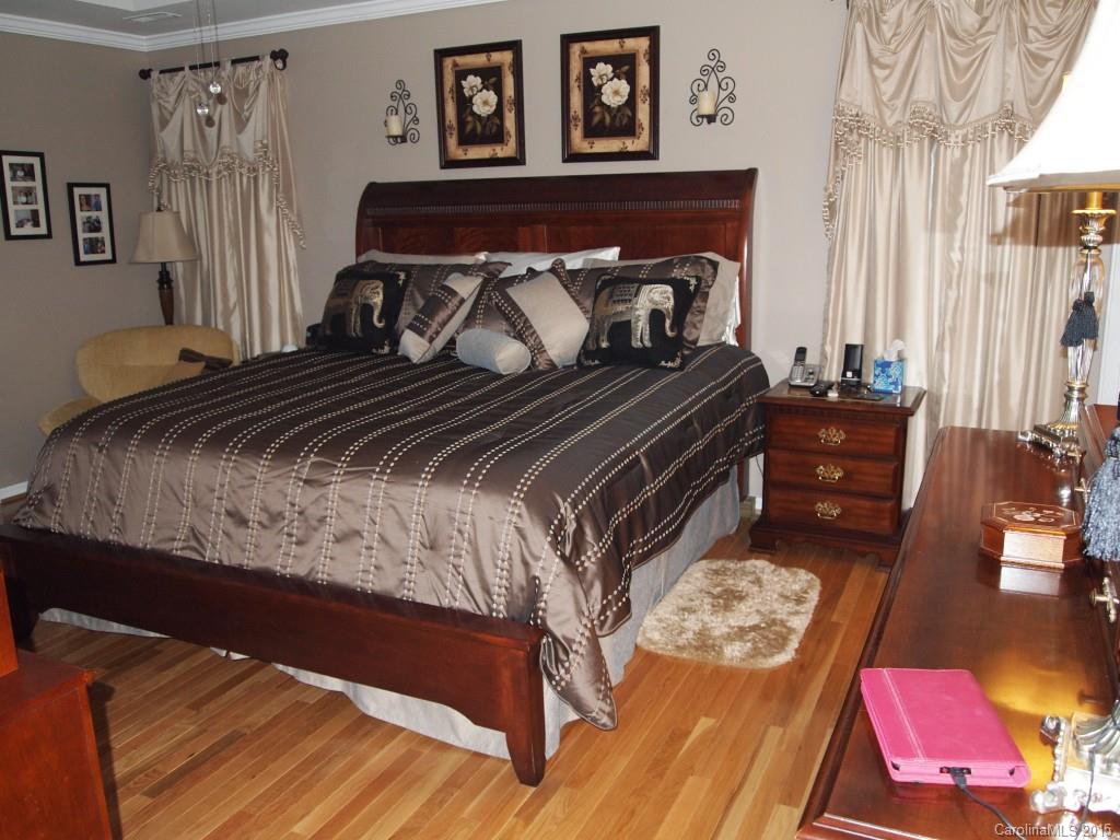603 Panthers Way, Unit 190 Fort Mill, SC 29708 - Photo 10 of 17 a bedroom with a bed and wooden floor