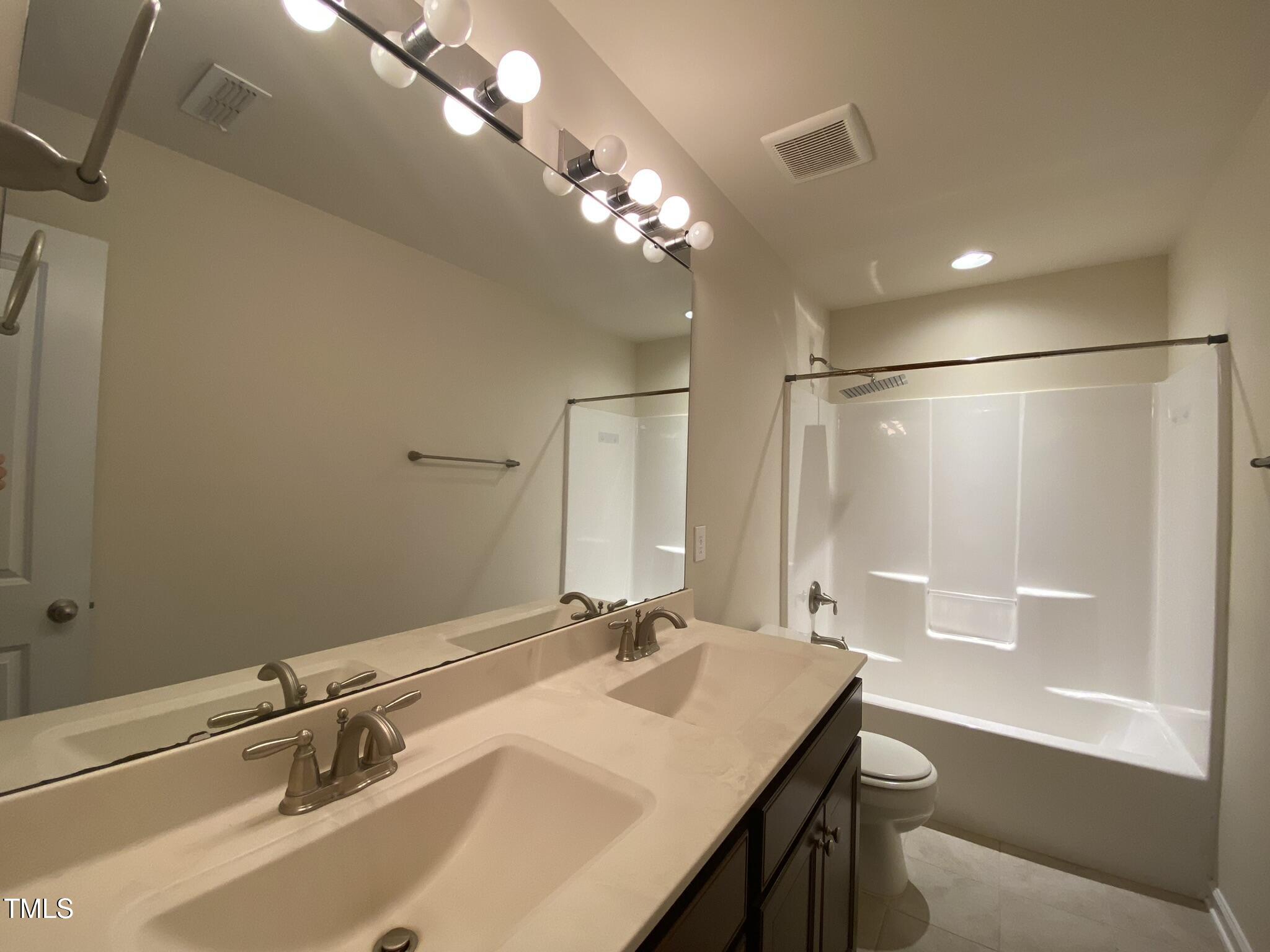 3545 Massey Ridge Court Raleigh, NC 27616 - Photo 21 of 38 a bathroom with a sink a large mirror and a bathtub