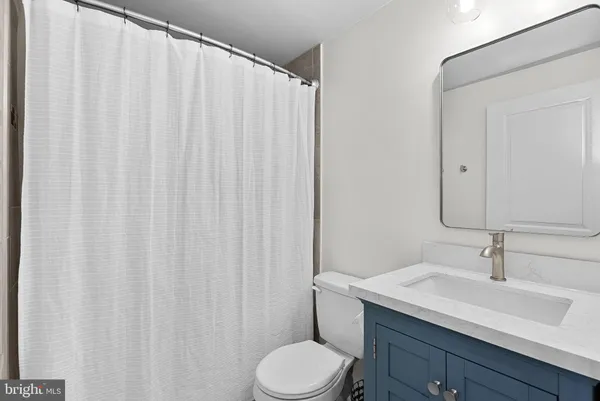 a bathroom with a sink a toilet and shower curtain