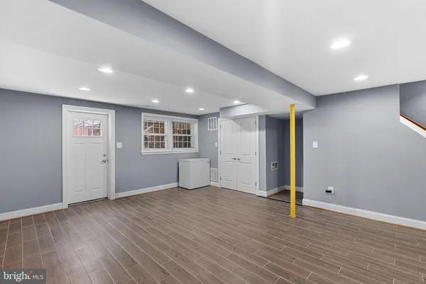 a view of an empty room with wooden floor and closet