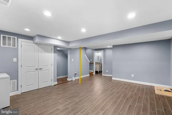 a view of an empty room with wooden floor and closet
