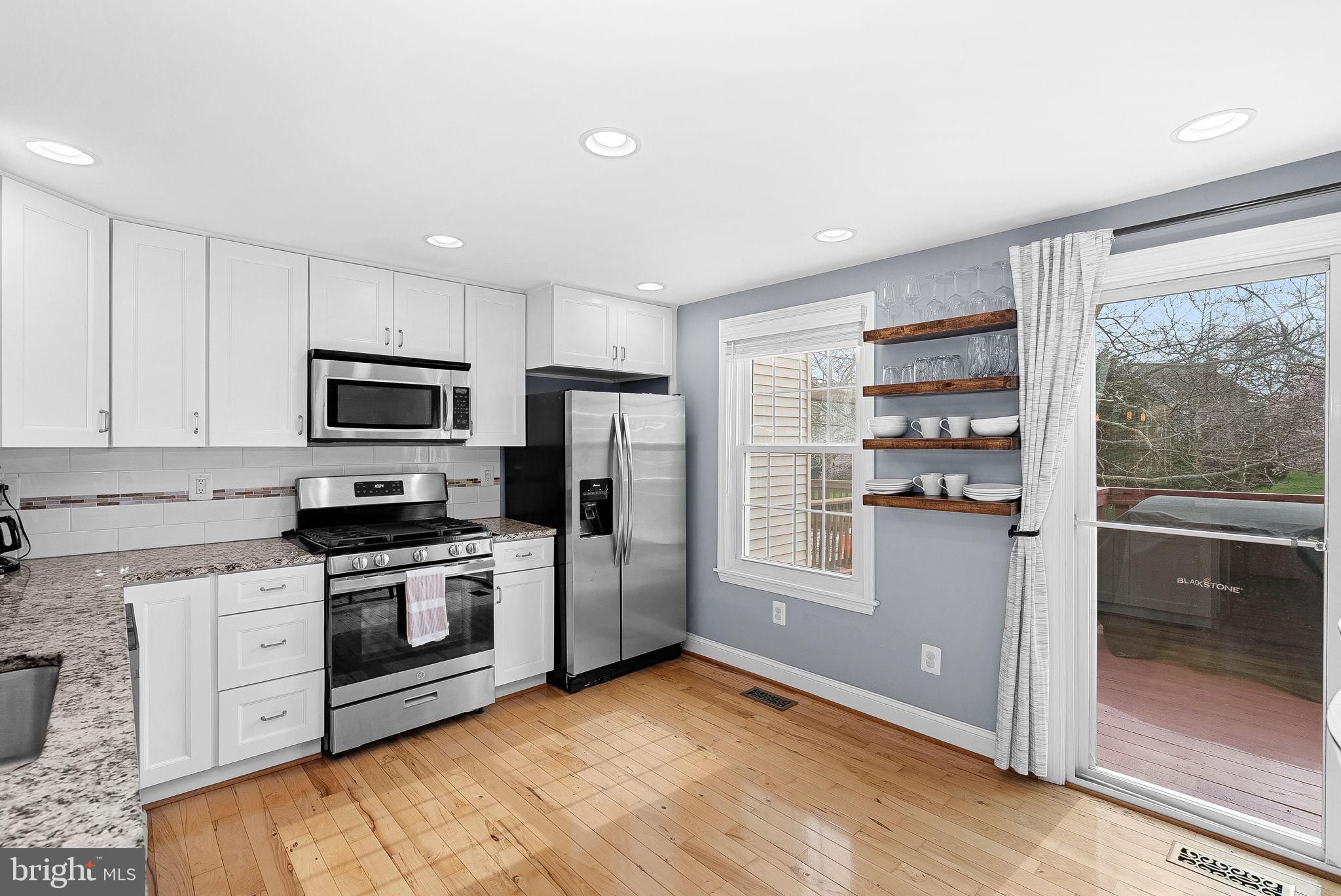 43983 Choptank Terrace Ashburn, VA 20147 - Photo 9 of 43 a kitchen with stainless steel appliances granite countertop a refrigerator a stove top oven and white cabinets