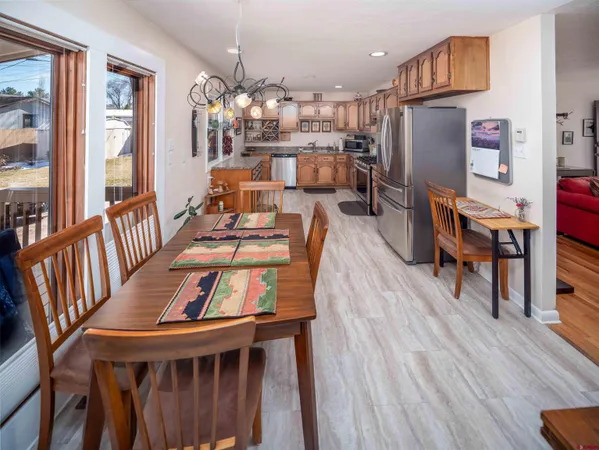 a kitchen with stainless steel appliances granite countertop a refrigerator a stove top oven and a sink with wooden floor
