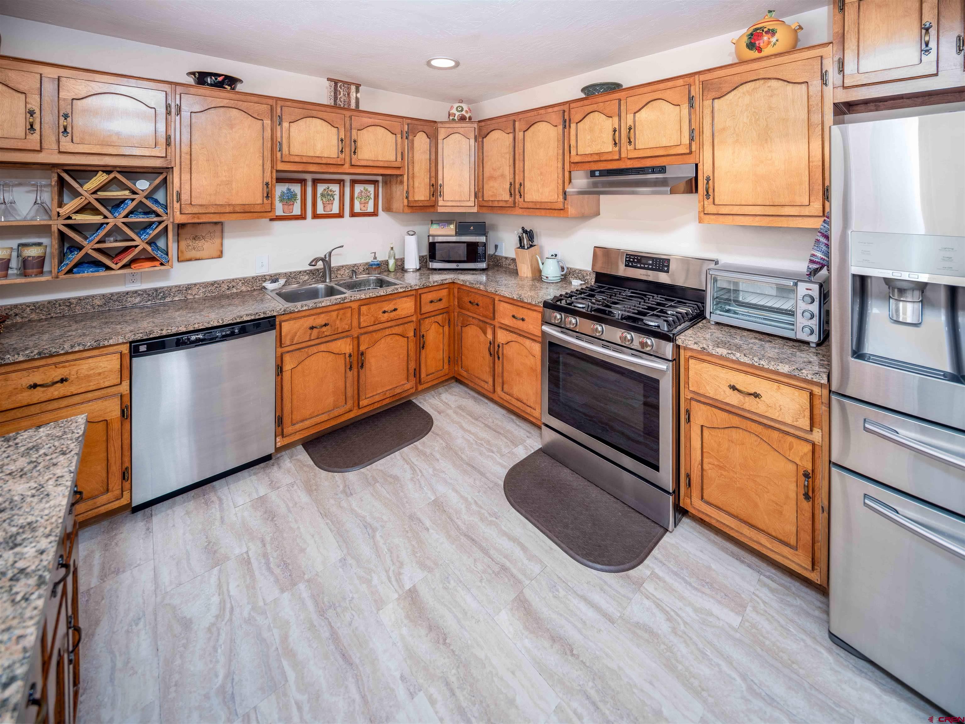 710 Wedgewood Street Cortez, CO 81321 - Photo 13 of 30 a kitchen with stainless steel appliances granite countertop a stove a sink and a microwave