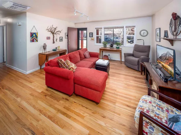 a living room with furniture and a wooden floor