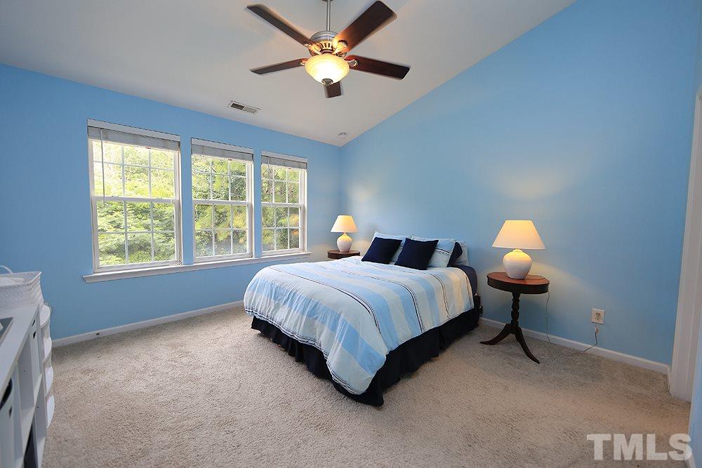 3715 Ramblewood Avenue Durham, NC 27713 - Photo 15 of 22 a spacious bedroom with a bed and a chandelier