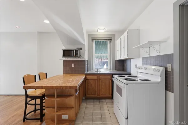 a kitchen with stainless steel appliances granite countertop a stove a sink dishwasher a refrigerator with a dining table and chairs