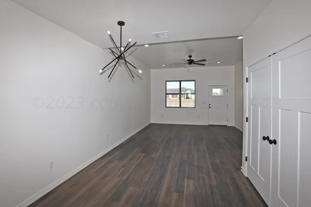 a kitchen with kitchen island granite countertop a sink a stove a refrigerator and white cabinets