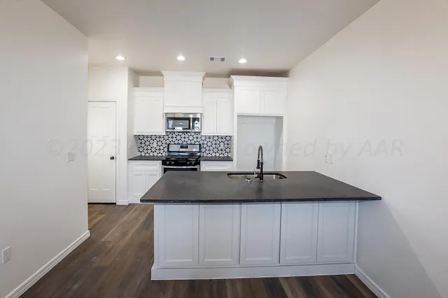 a view of a kitchen with a sink and wooden floor