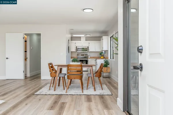 a living room with furniture a dining table and chairs with wooden floor