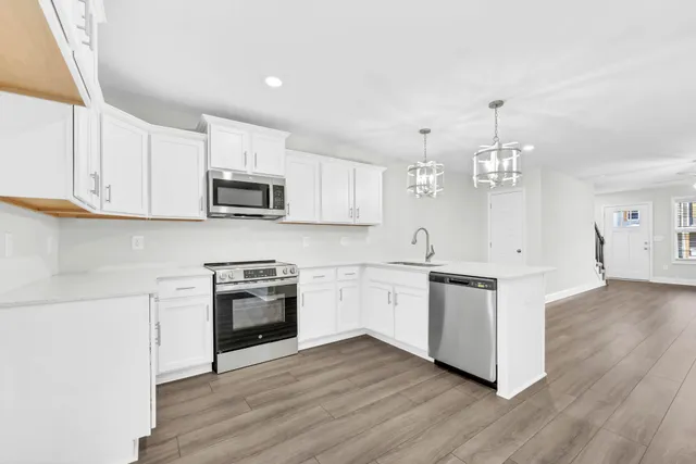 a kitchen with granite countertop white cabinets and stainless steel appliances