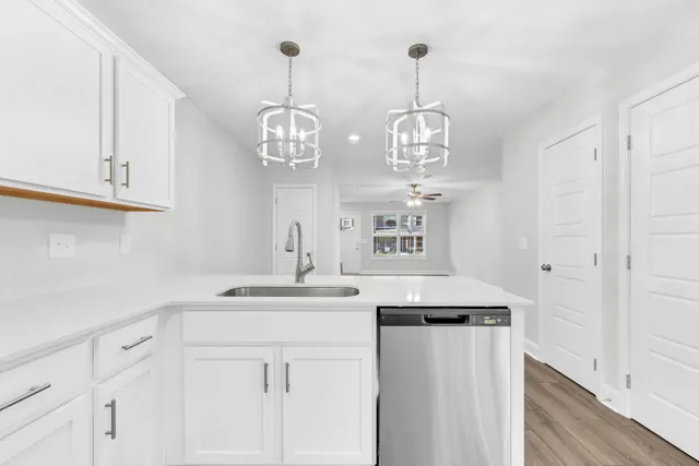 a kitchen with stainless steel appliances granite countertop white cabinets a sink and dishwasher