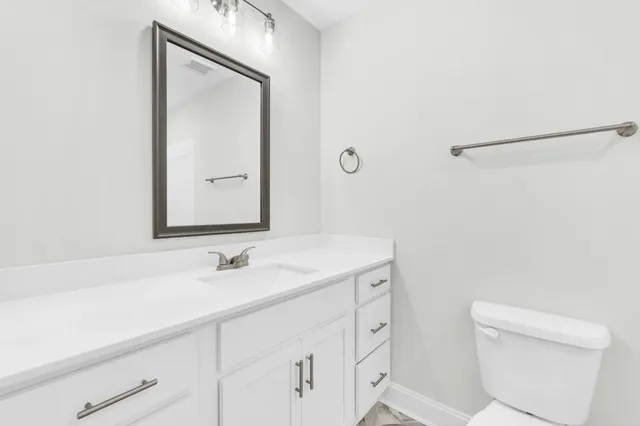 a bathroom with a sink a toilet and a mirror