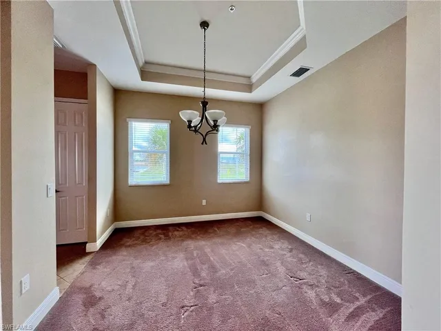 a view of an empty room and kitchen view