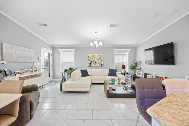 a living room with furniture a flat screen tv and a large window