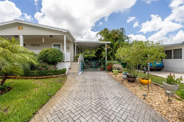 a view of a house with a big yard and large trees