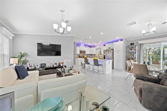 a living room with furniture kitchen view and a flat screen tv