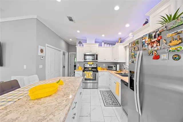 a kitchen with stainless steel appliances lots of white cabinets