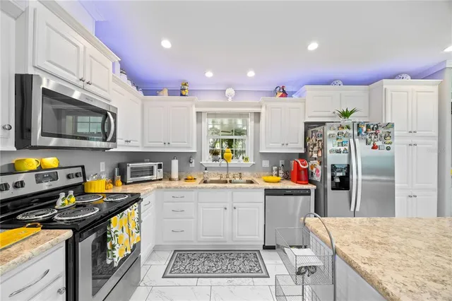 a kitchen with stainless steel appliances granite countertop a stove top oven a sink dishwasher and cabinets with wooden floor