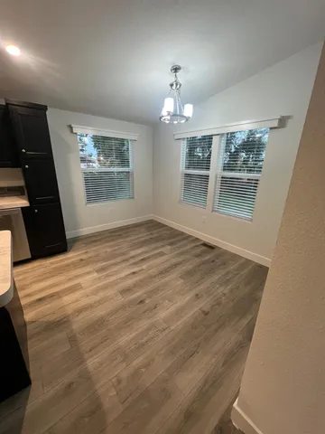 a large kitchen with a stove a sink dishwasher and a refrigerator with wooden floor