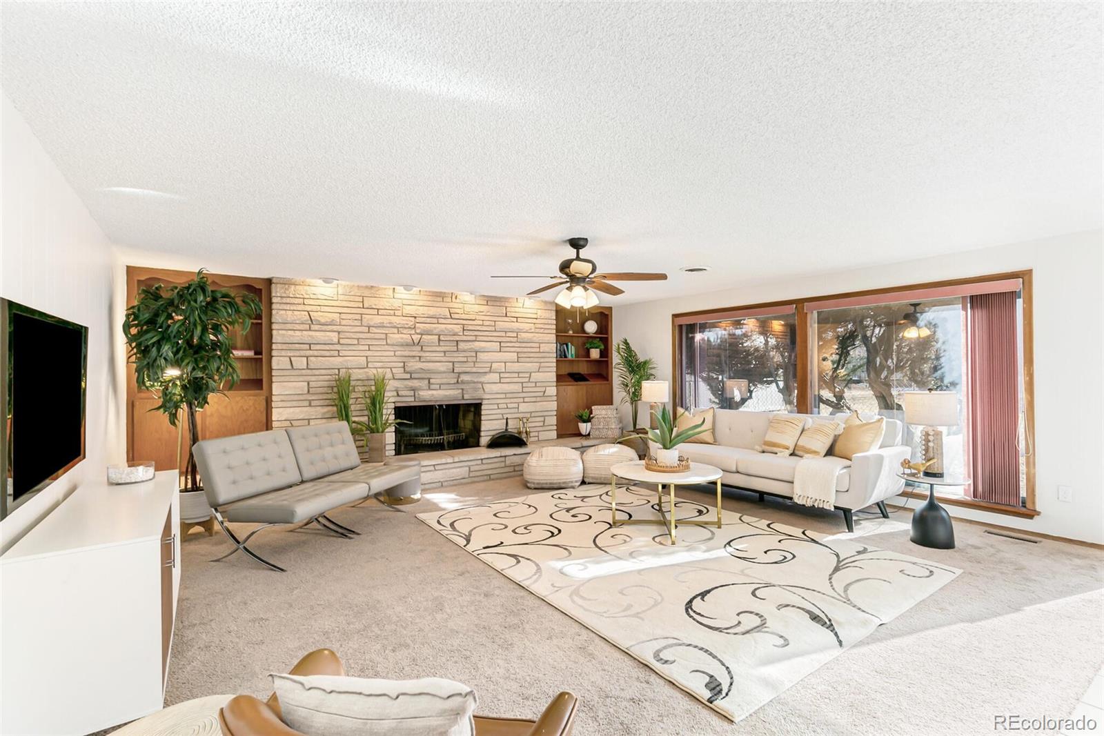 4650 Reed Street Wheat Ridge, CO 80033 - Photo 17 of 40 a living room with furniture a large window and a fireplace