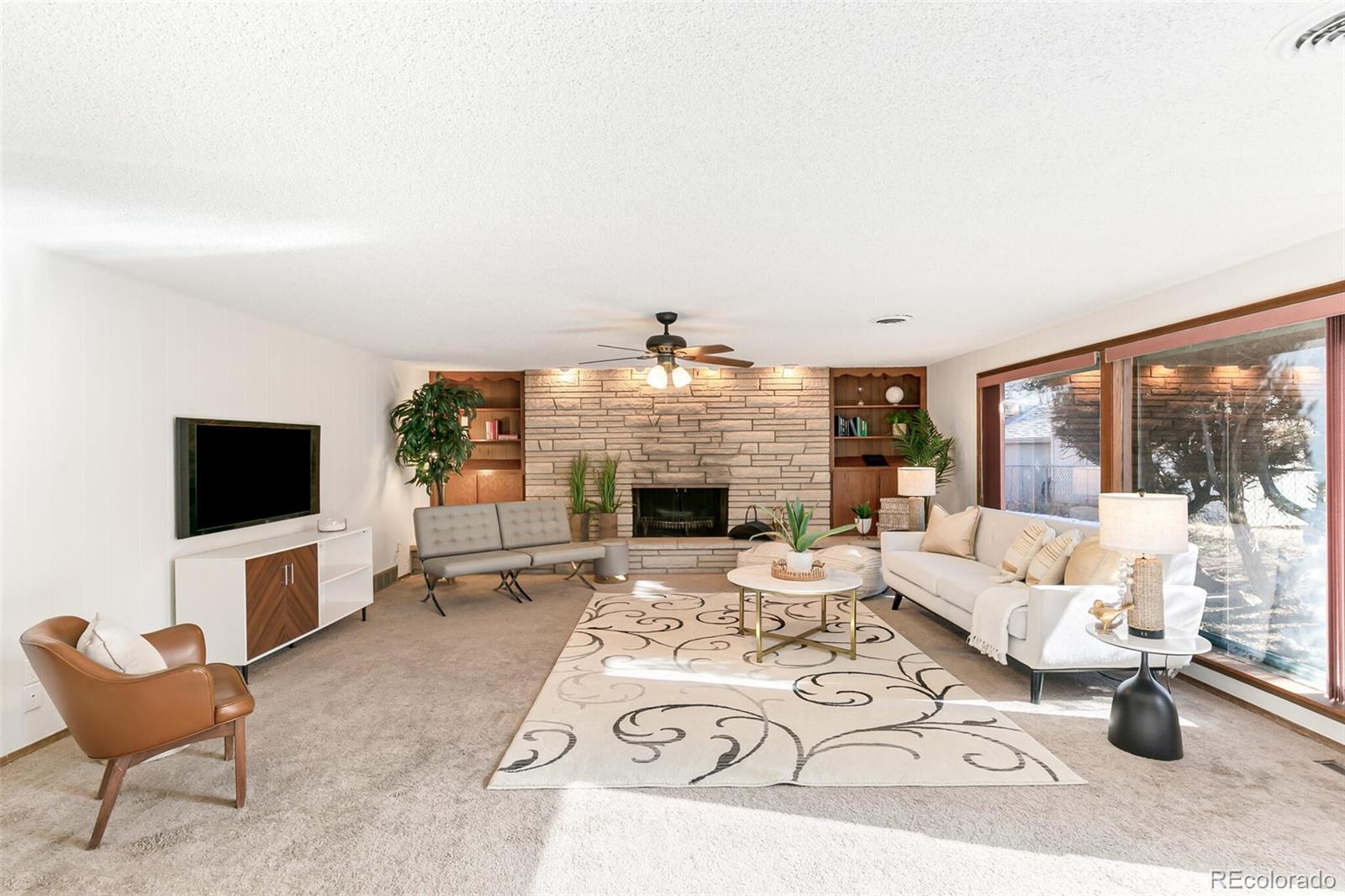 4650 Reed Street Wheat Ridge, CO 80033 - Photo 18 of 40 a living room with furniture a fireplace and a flat screen tv