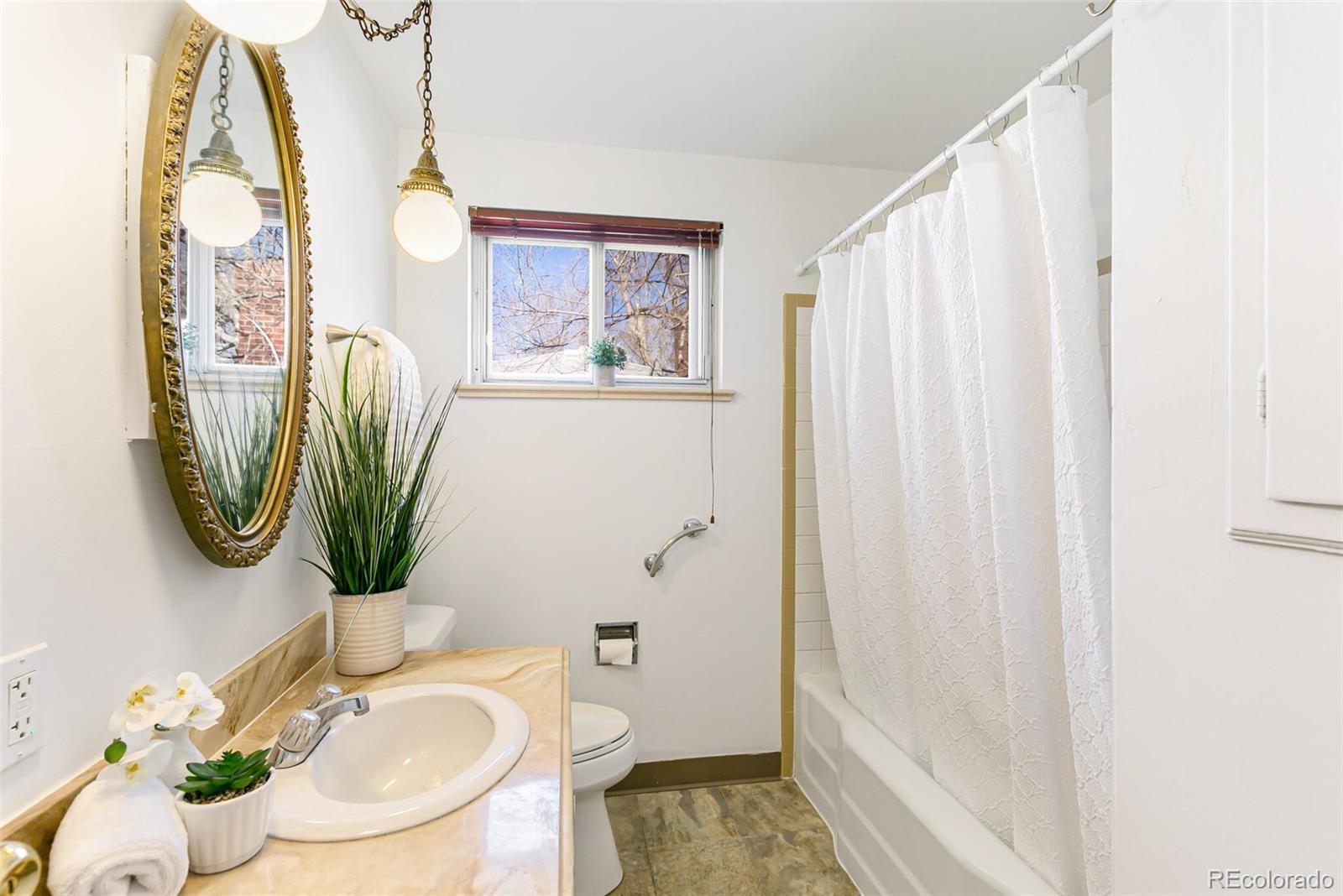 4650 Reed Street Wheat Ridge, CO 80033 - Photo 27 of 40 a bathroom with a sink toilet and mirror