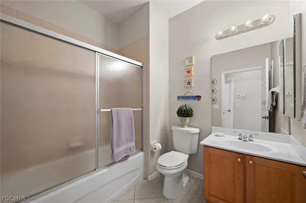 a bathroom with a toilet a sink and a large mirror