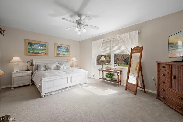 a spacious bedroom with a bed a couch and a chandelier