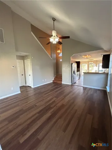 a view of an empty room with window and wooden floor