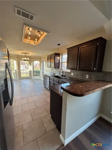 a kitchen with stainless steel appliances granite countertop a sink stove and cabinets