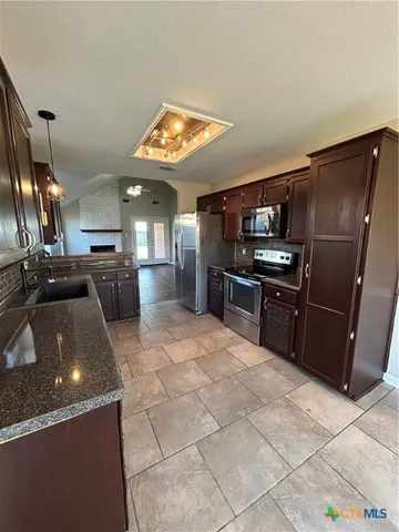 a kitchen with stainless steel appliances granite countertop a sink stove and refrigerator