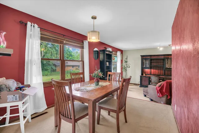 a kitchen with a sink a stove a refrigerator cabinets and a dining table