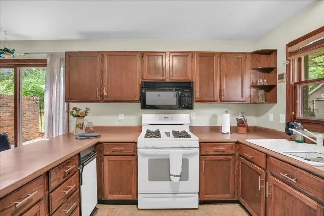 a white kitchen with sink and refrigerator