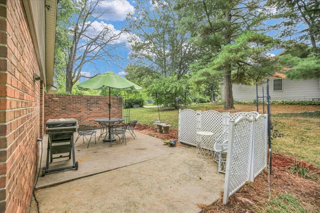 a view of a patio with a table chairs and a swimming pool