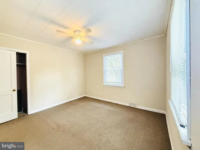 an empty room with a window and a ceiling fan