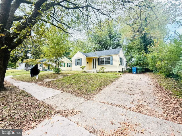 a front view of a house with a yard and trees