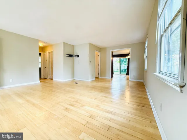 a view of a big room with wooden floor and windows