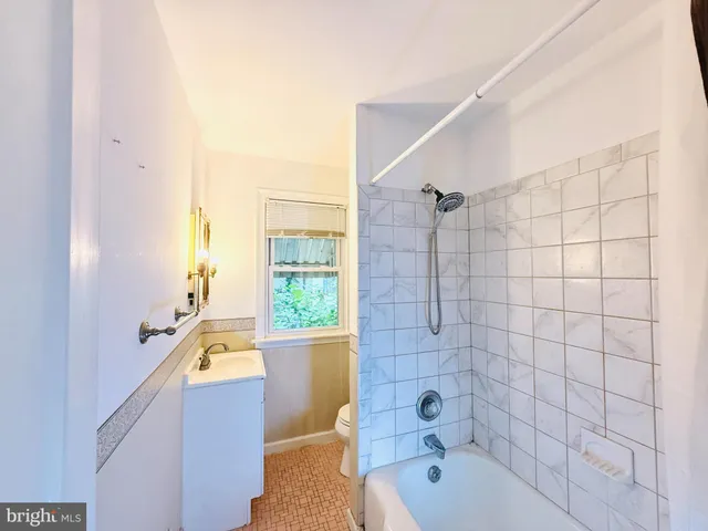a bathroom with a tub a sink and a window