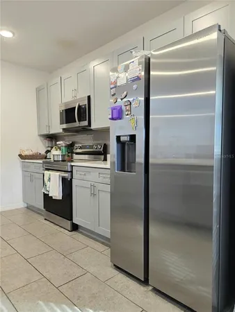 a kitchen with stainless steel appliances kitchen island granite countertop a refrigerator and a stove