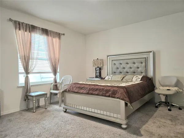 a bedroom with a bed chair and window