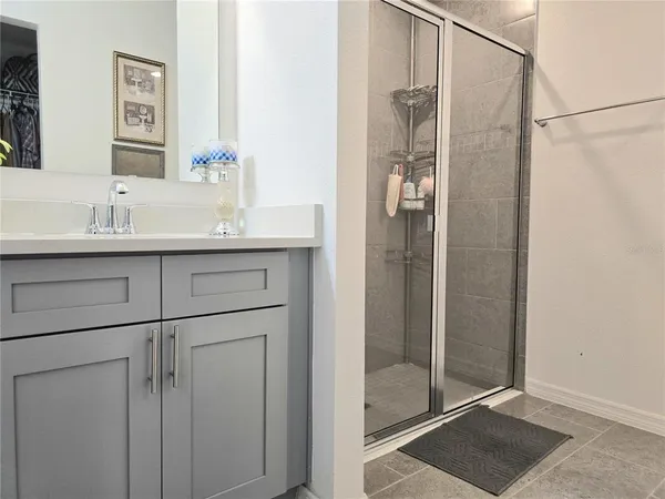 a bathroom with a shower sink and mirror