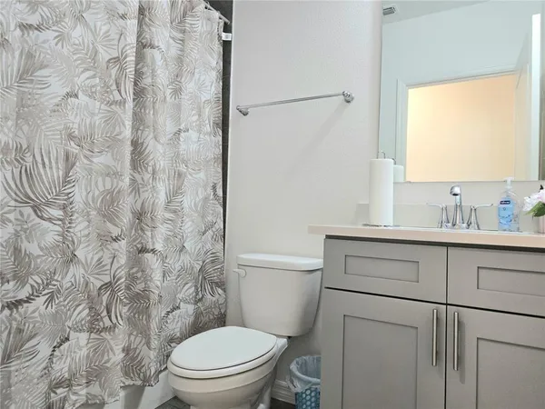 a bathroom with a granite countertop toilet sink and mirror