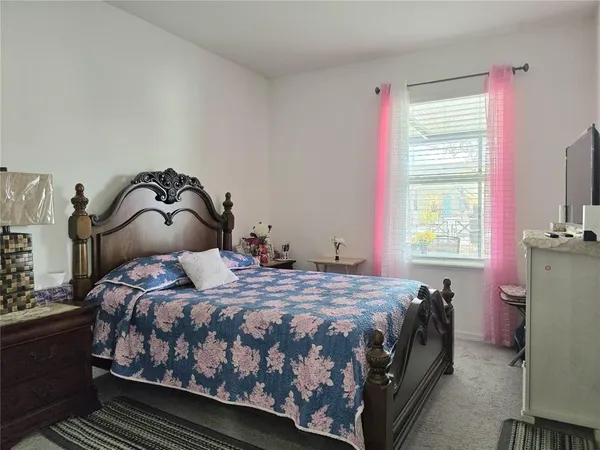 a bedroom with a bed next to a window