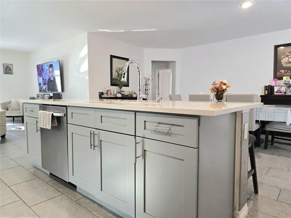 a kitchen with white cabinets appliances and chairs