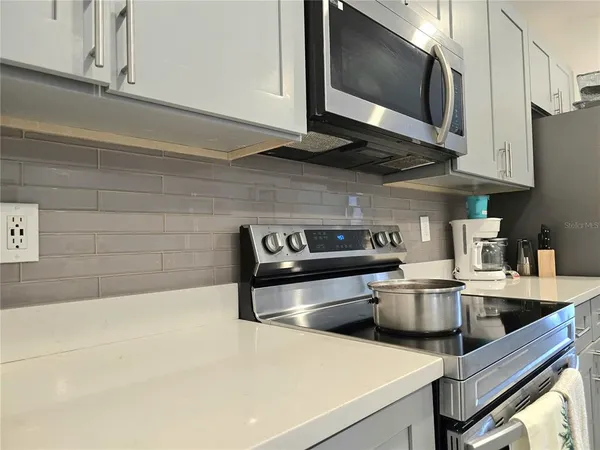 a kitchen with stainless steel appliances a stove a microwave and cabinets