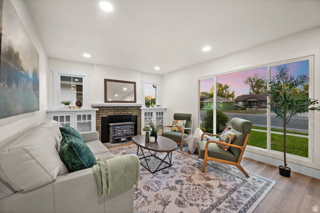 189 West Center Street Midvale, UT 84047 - Photo 6 of 64 Living space featuring recessed lighting, large picture windows, wood-finish flooring, and a brick fireplace with a built-in wood-burning stove
